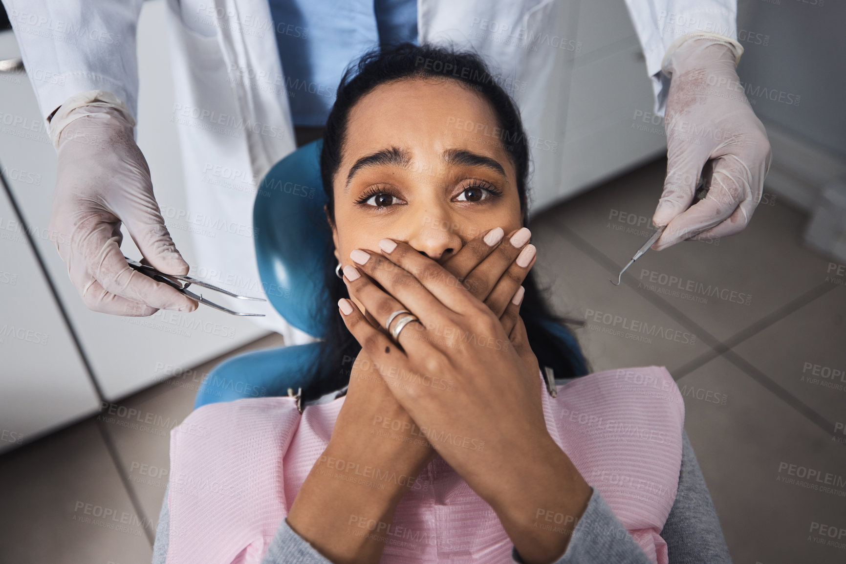 Buy stock photo Shot of a young woman looking scared while having dental work done on her teeth