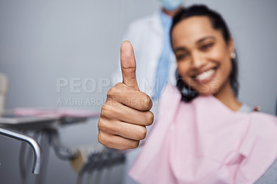 Buy stock photo Portrait of a young woman showing thumbs during her dental appointment