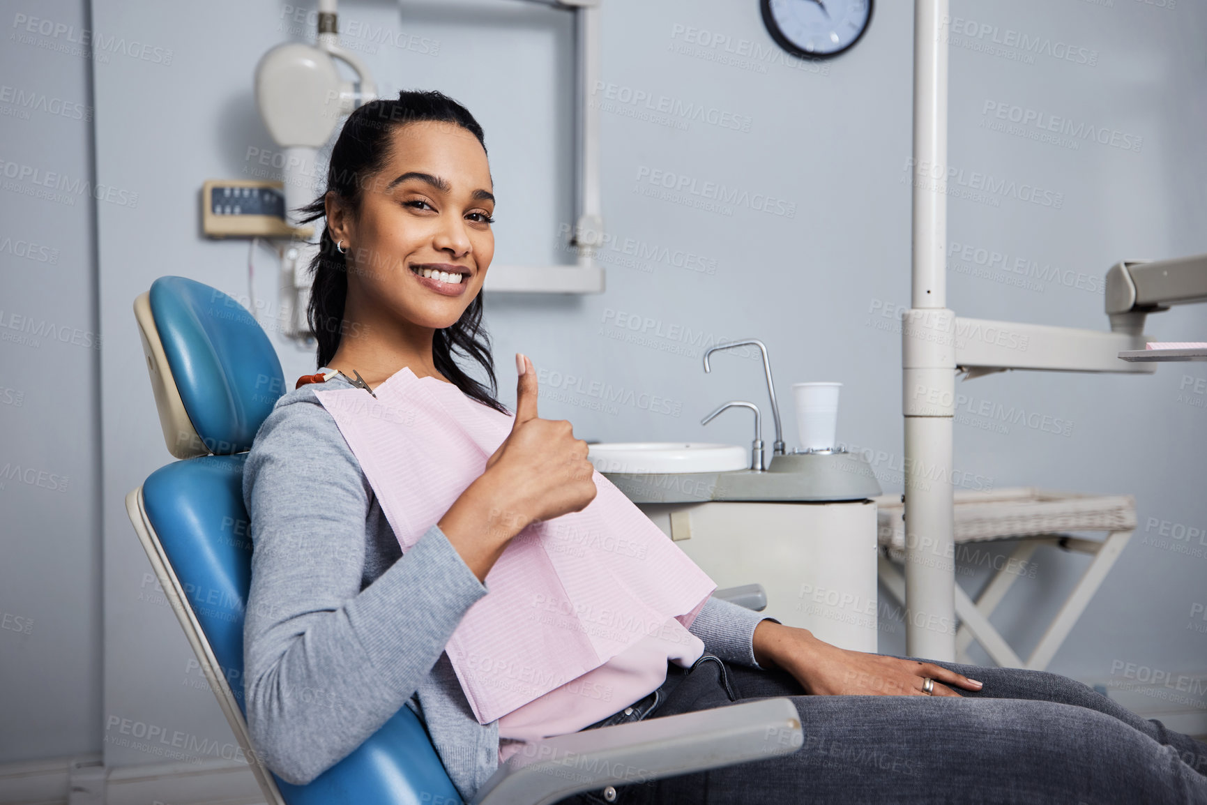 Buy stock photo Portrait of a young woman showing thumbs during her dental appointment