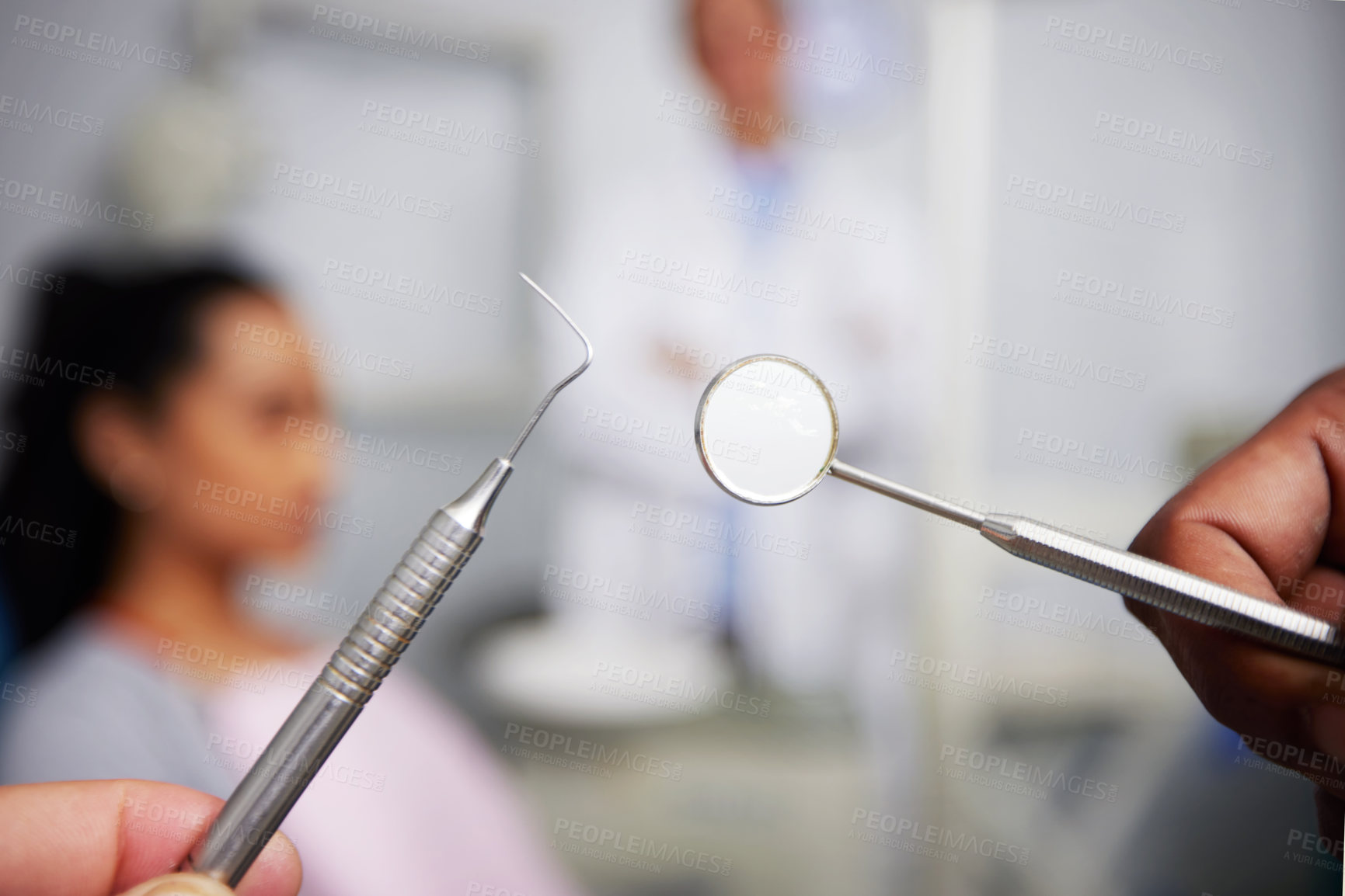 Buy stock photo Shot of an unrecognisable dentist holding dental tools in an office