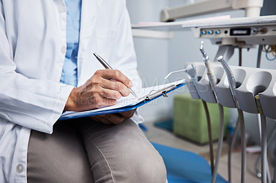 Buy stock photo Shot of an unrecognisable dentist writing notes on a piece of paper