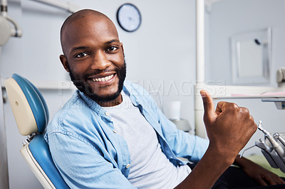Buy stock photo Portrait of a young man showing thumbs during his dental appointment