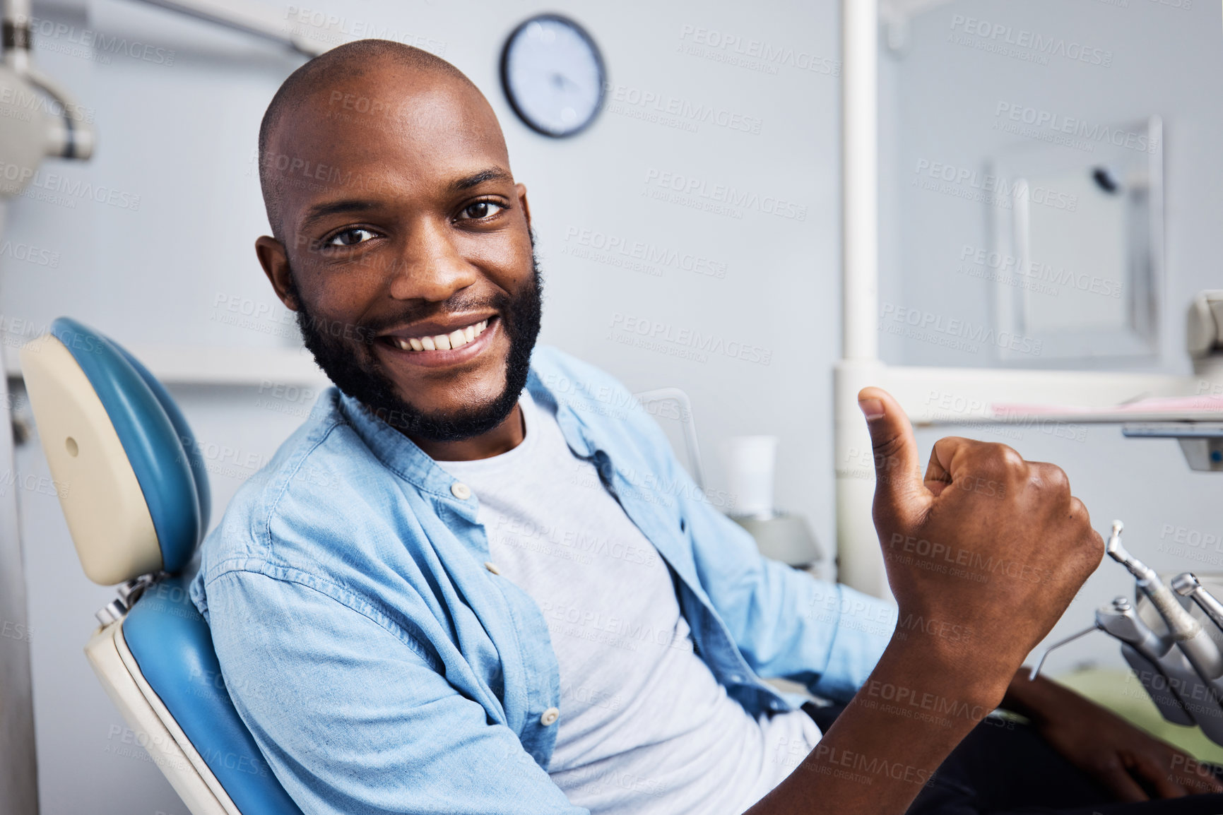 Buy stock photo Portrait of a young man showing thumbs during his dental appointment