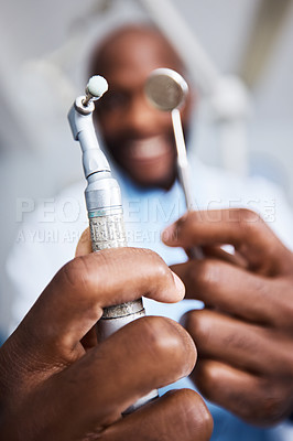 Buy stock photo Portrait of a young man holding teeth cleaning tools in his dentist’s office