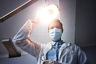 Buy stock photo Low angle shot of a dentist getting ready to perform a procedure on a patient