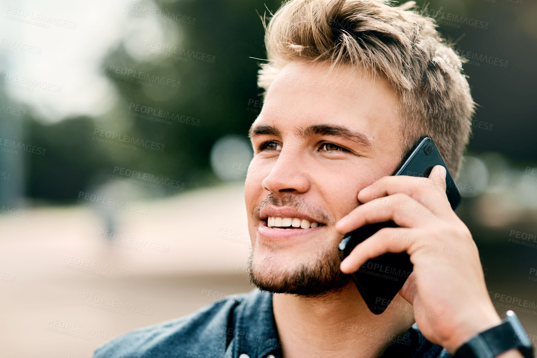 Buy stock photo Listening, college student or man with phone call on campus, smile or connection for scholarship update. Nature, space or person with tech for communication, education institution news or networking