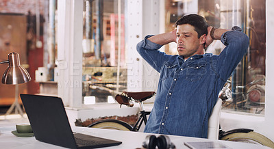 Buy stock photo Cropped shot of a man looking stressed while working on his laptop in his workshop