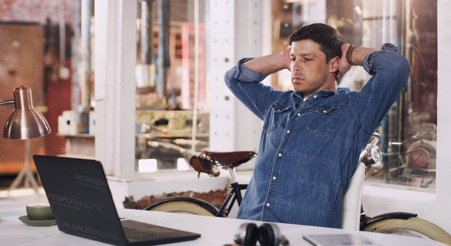 Buy stock photo Cropped shot of a man looking stressed while working on his laptop in his workshop