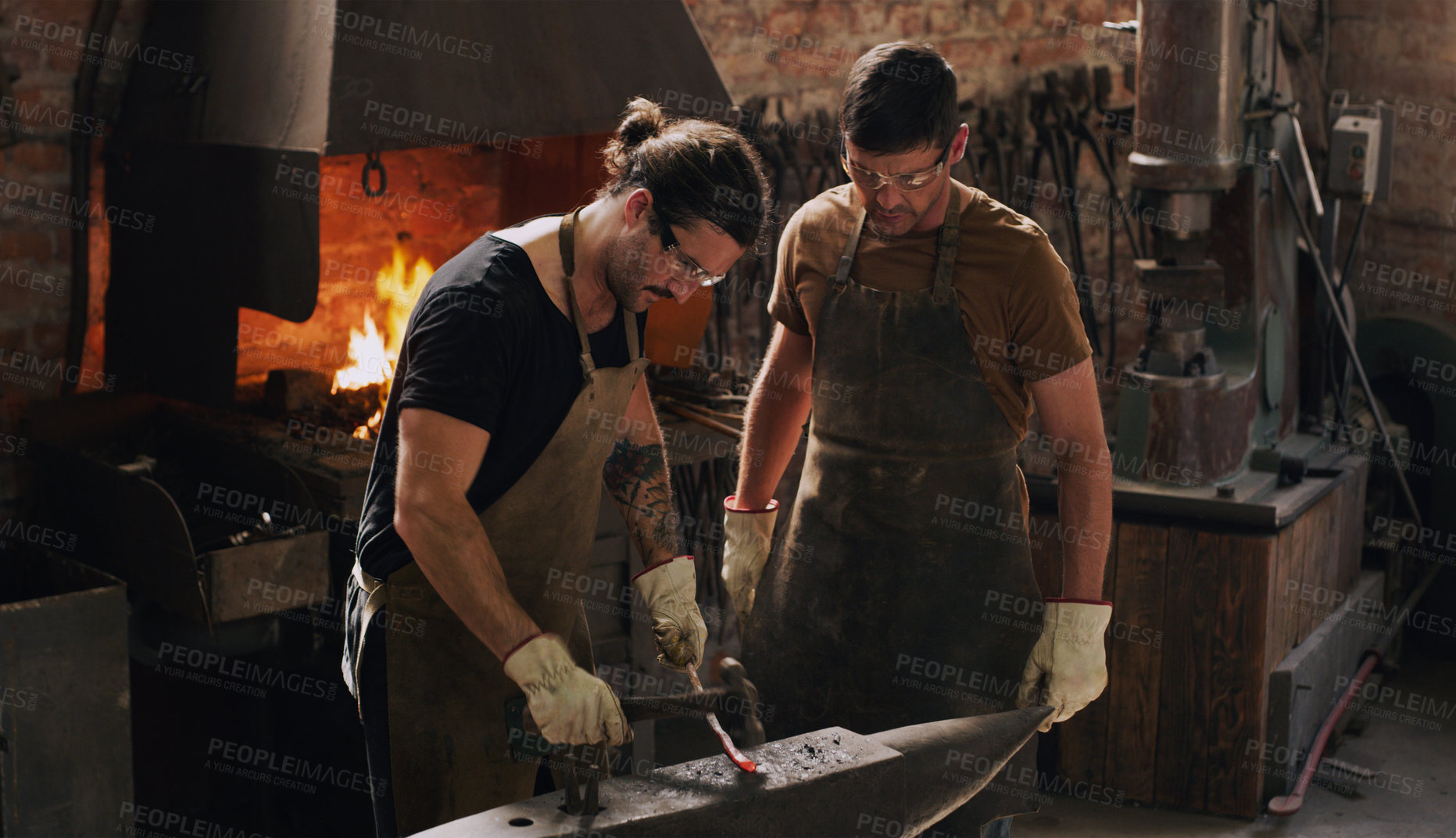 Buy stock photo Blacksmith, colleagues and hammer with metal, flame and equipment for professional craft. Protection, teamwork and gloves in workshop with anvil for metalwork, forge and iron product creation factory