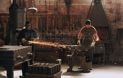 Buy stock photo Hammer, anvil and sparks with men working in a forge for metal work manufacturing or production. Industry, welding and trade with a young male blacksmith in a workshop, plant or industrial foundry