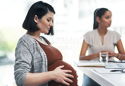 Buy stock photo Shot of a pregnant young businesswoman having a team meeting in a modern office