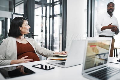 Buy stock photo Shot of a pregnant young businesswoman having a team meeting in a modern office