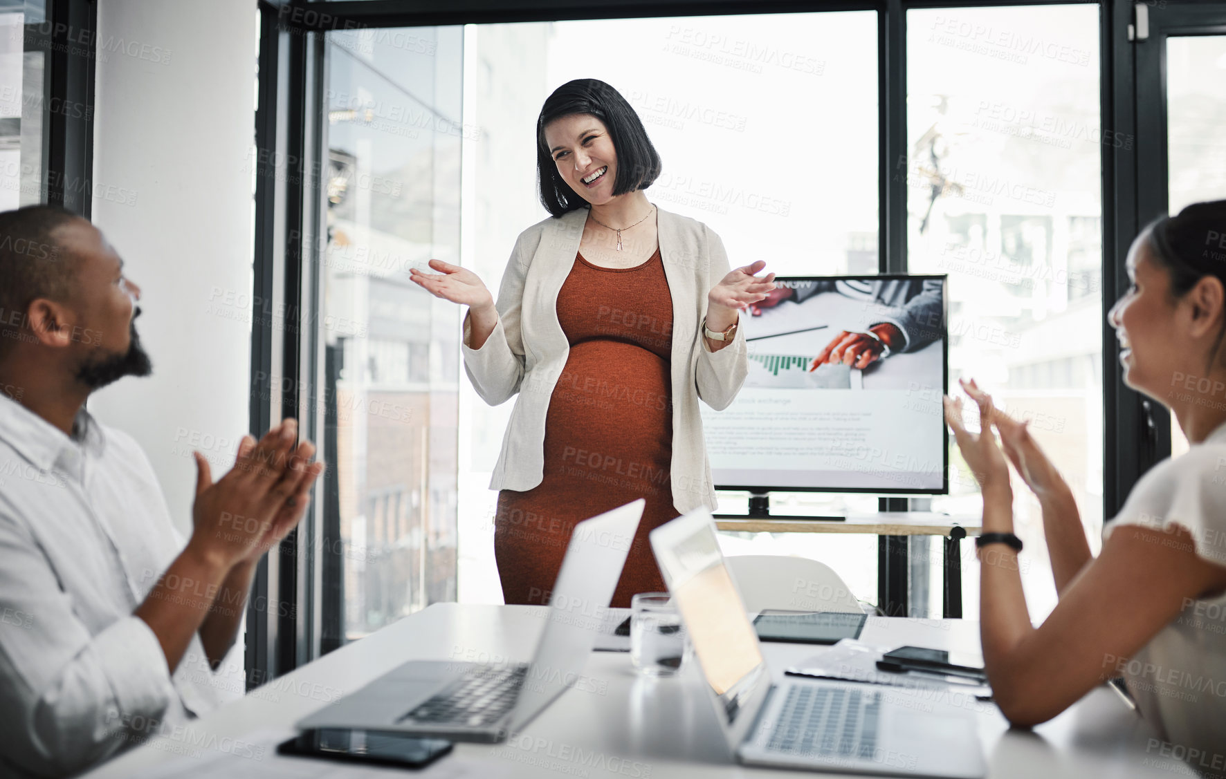 Buy stock photo Shot of a group of businesspeople clapping during a meeting with their pregnant colleague in a modern office
