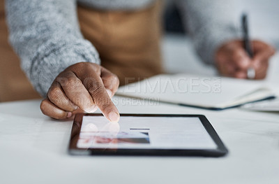 Buy stock photo Cropped shot of an unrecognizable businessman sitting alone in the office and using a tablet