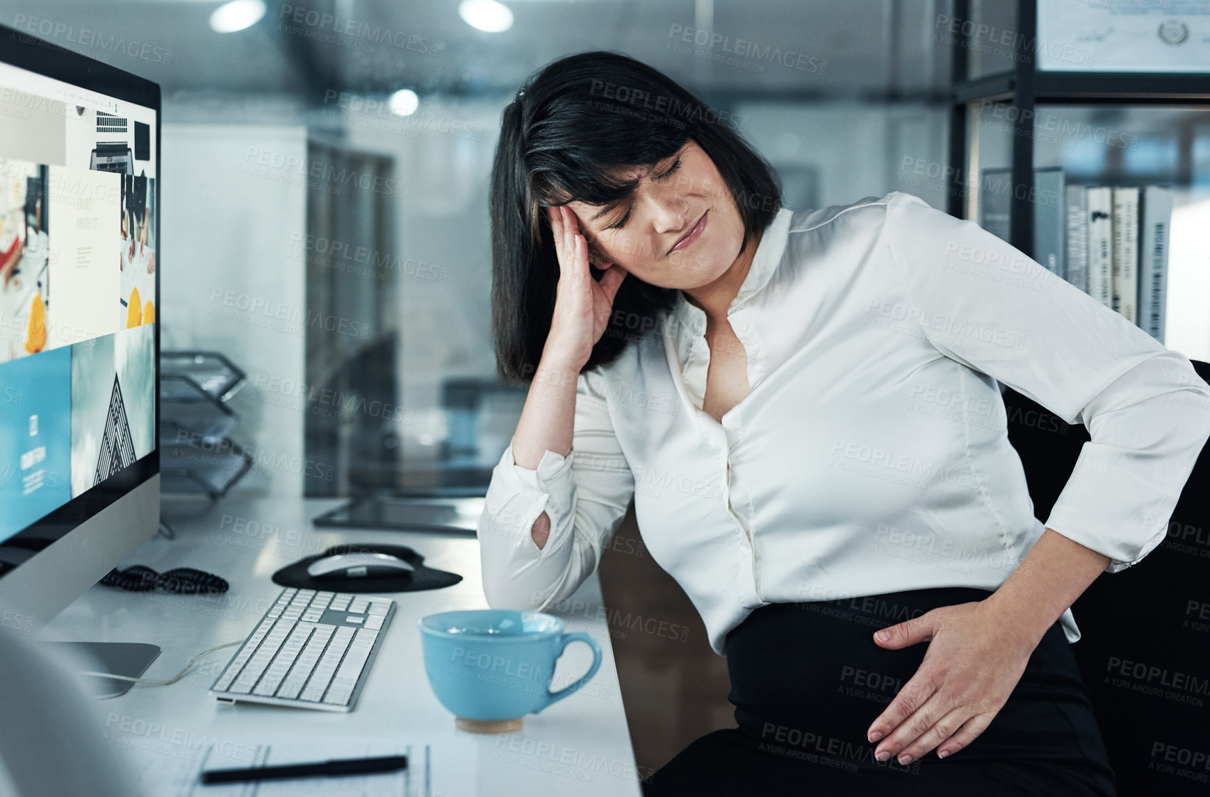 Buy stock photo Cropped shot of an attractive pregnant businesswoman sitting alone in the office and suffering from abdominal pain
