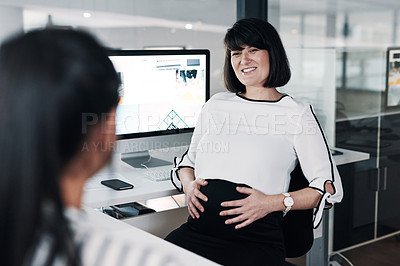 Buy stock photo Cropped shot of an attractive pregnant businesswoman sitting with a colleague in the office