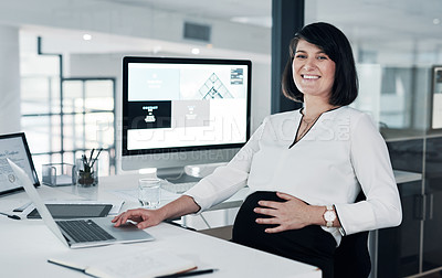 Buy stock photo Cropped shot of an attractive pregnant businesswoman sitting in her office and using her laptop while holding her tummy