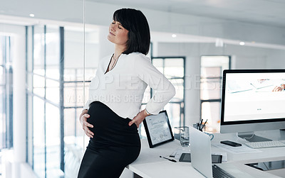 Buy stock photo Cropped shot of an attractive pregnant businesswoman standing alone in the office and suffering from abdominal pain