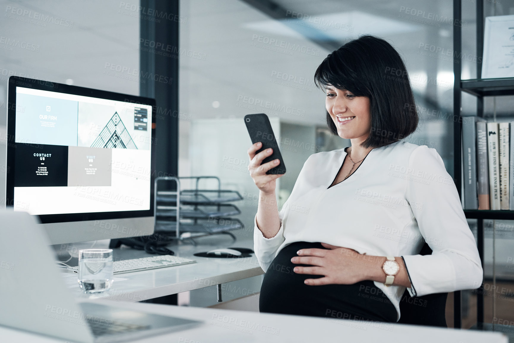 Buy stock photo Cropped shot of an attractive pregnant businesswoman sitting alone in the office and using her cellphone