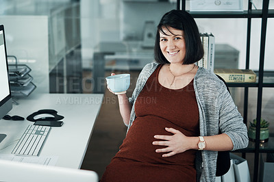 Buy stock photo Cropped shot of an attractive pregnant businesswoman sitting alone in the office and having a cup of tea
