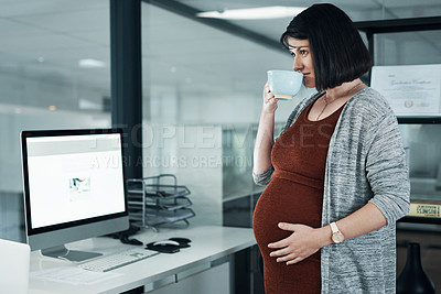 Buy stock photo Cropped shot of an attractive pregnant businesswoman standing alone in the office and having a cup of tea