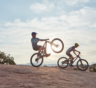 Buy stock photo Full length shot of two men out mountain biking together during the day