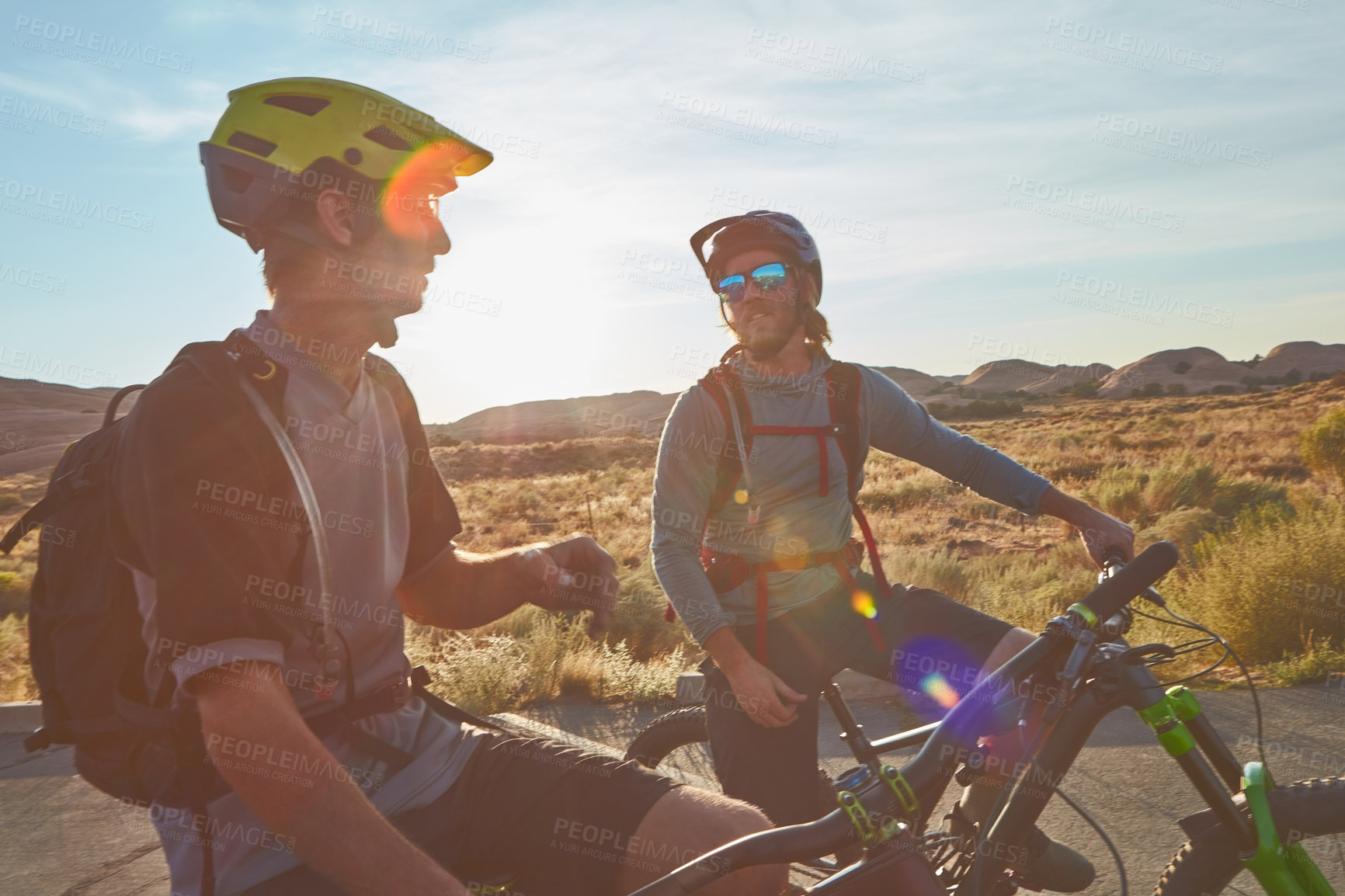 Buy stock photo Cropped shot of two young male athletes mountain biking in the wilderness