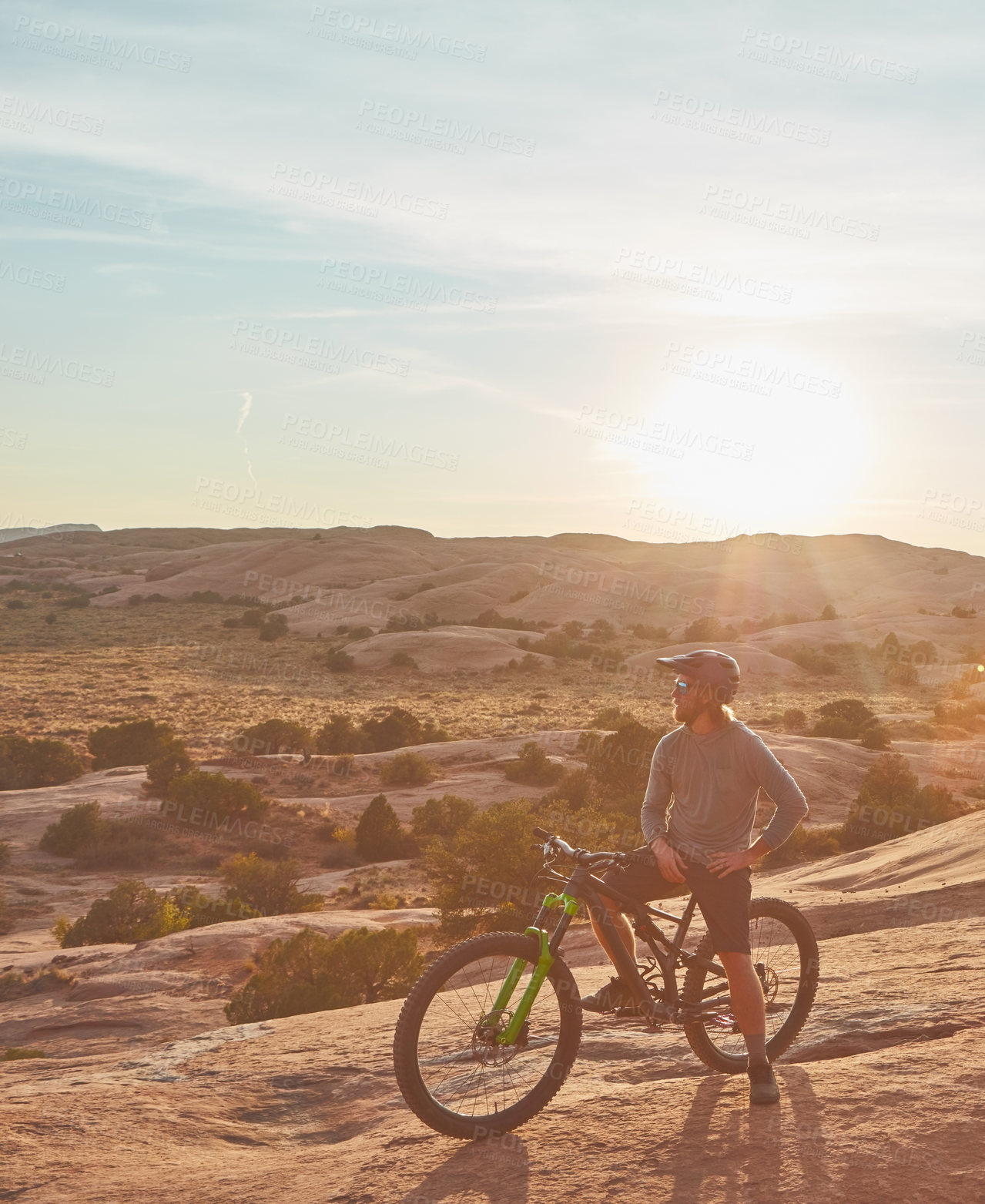 Buy stock photo Full length shot of two young male athletes mountain biking in the wilderness