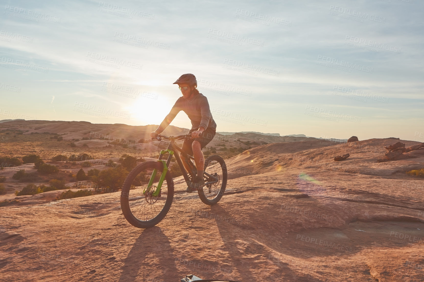 Buy stock photo Full length shot of a young male athlete mountain biking in the wilderness