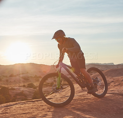 Buy stock photo Full length shot of a young male athlete mountain biking in the wilderness