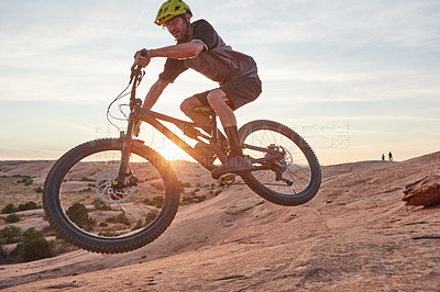 Buy stock photo Full length shot of a young male athlete mountain biking in the wilderness