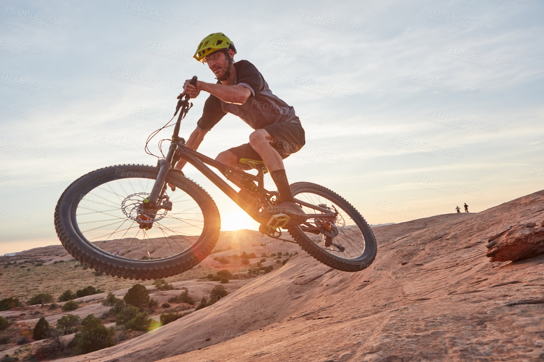 Buy stock photo Full length shot of a young male athlete mountain biking in the wilderness