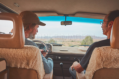 Buy stock photo Shot of two men smoking together while out on a road trip