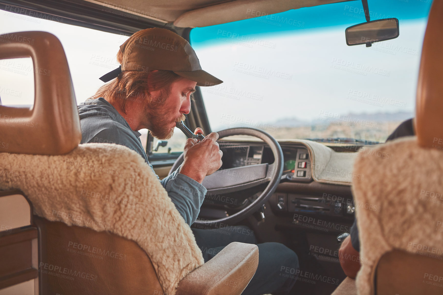 Buy stock photo Cropped shot of a man smoking while out on a road trip