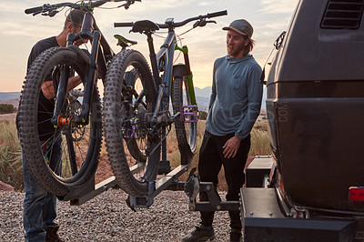 Buy stock photo Shot of two mountain bikers unloading their gear