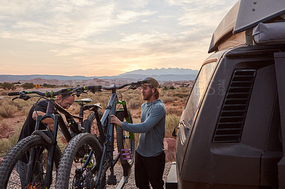 Buy stock photo Shot of two mountain bikers unloading their gear