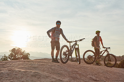 Buy stock photo Full length shot of two men out mountain biking together during the day