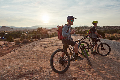 Buy stock photo Full length shot of two men out mountain biking together during the day