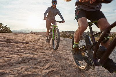 Buy stock photo Shot of two men out mountain biking together during the day