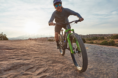 Buy stock photo Shot of a young man out mountain biking during the day