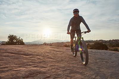 Buy stock photo Shot of a young man out mountain biking during the day