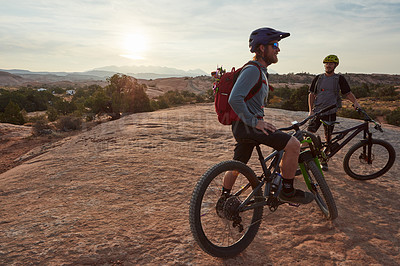 Buy stock photo Full length shot of two men out mountain biking together during the day