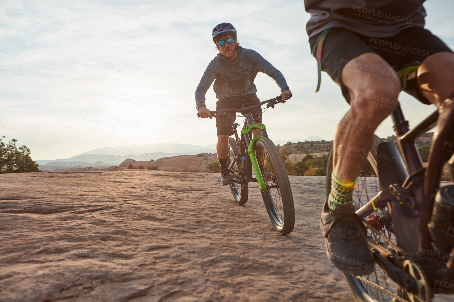 Buy stock photo Shot of two men out mountain biking together during the day