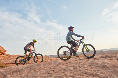 Buy stock photo Full length shot of two men out mountain biking together during the day