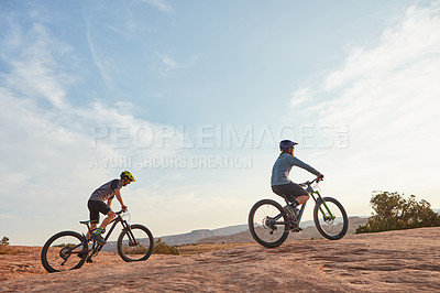 Buy stock photo Full length shot of two men out mountain biking together during the day