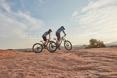 Buy stock photo Full length shot of two men out mountain biking together during the day