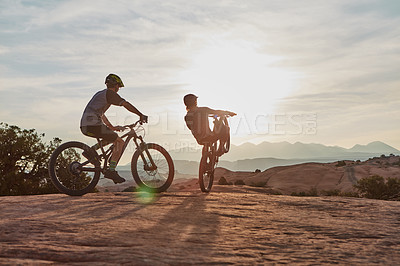 Buy stock photo Full length shot of two men out mountain biking together during the day