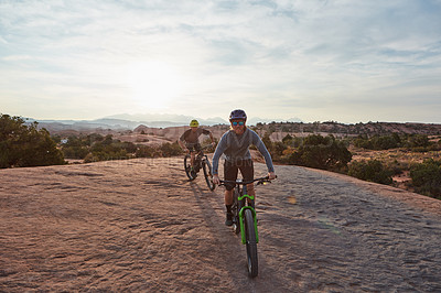 Buy stock photo Full length shot of two men out mountain biking together during the day