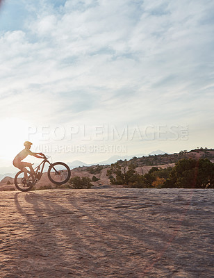 Buy stock photo Shot of a young man out mountain biking during the day