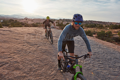 Buy stock photo Full length shot of two men out mountain biking together during the day